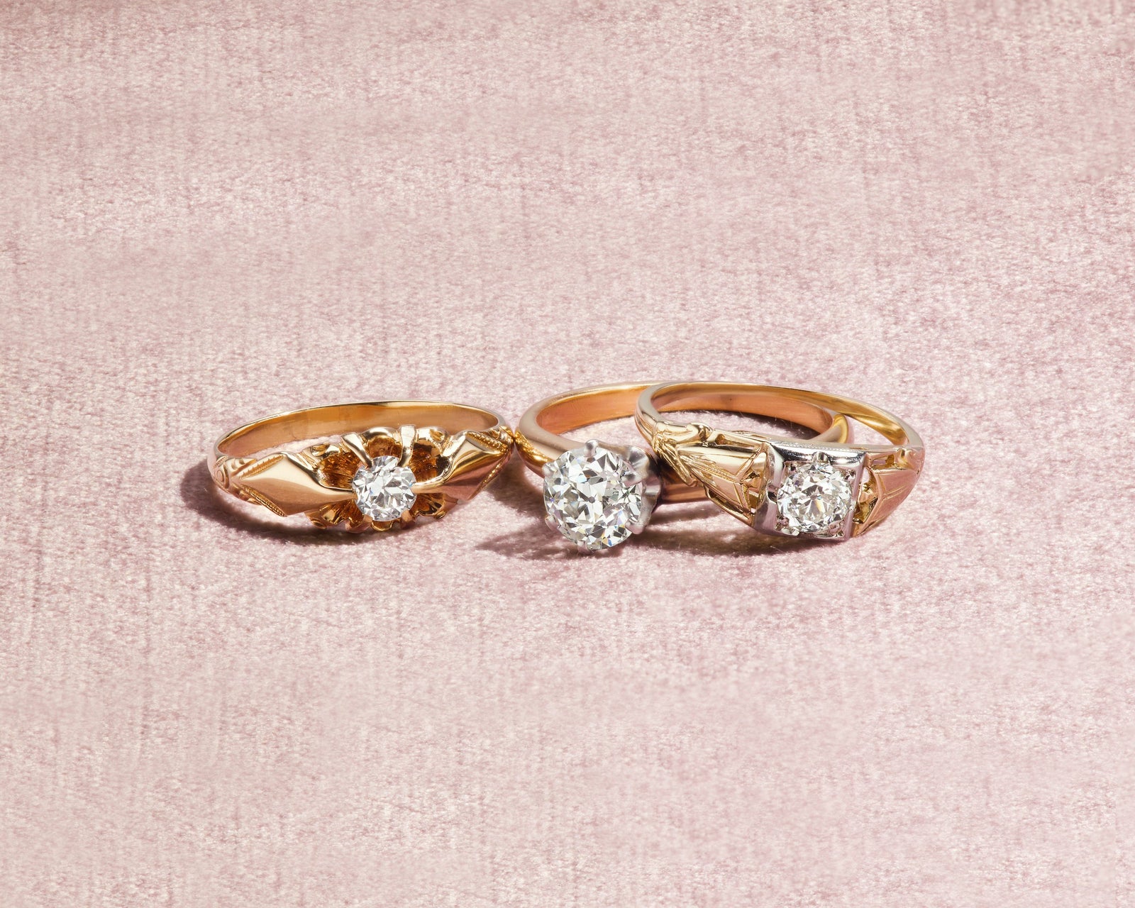 Three antique diamond solitaire rings in gold on blush linen